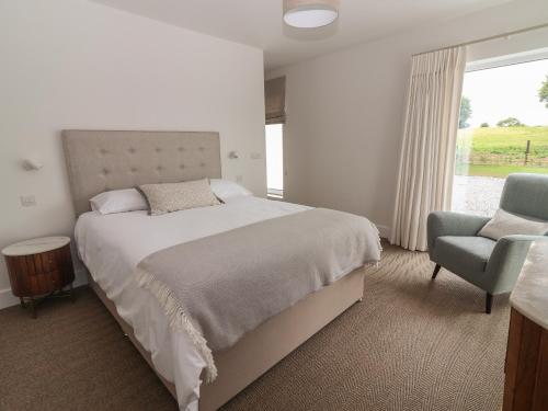 a bedroom with a bed and a chair and a window at Shannon Vale in Woodford