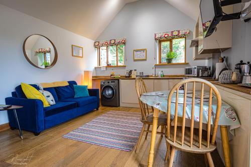 sala de estar con sofá azul y mesa en Hay Barn en Winterton-on-Sea