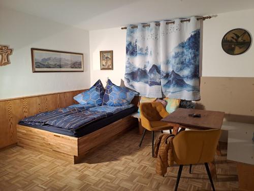 a bedroom with a bed and a table with chairs at Ferienwohnung Jakob in Neustift im Stubaital