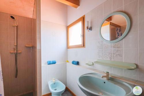 ein Badezimmer mit einem Waschbecken, einem WC und einem Spiegel in der Unterkunft Biscarrosse Bourg, Maison pour 6 personnes avec Terrasse et jardin in Biscarrosse