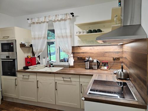 a kitchen with white cabinets and a sink at Chata Sára in Janske Lazne