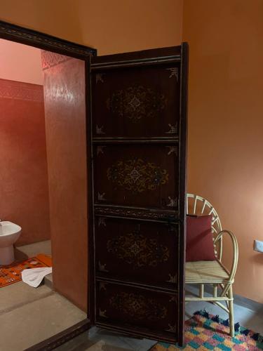 a black dresser in a room with a chair at RIAD DAR NAOMI in Marrakesh