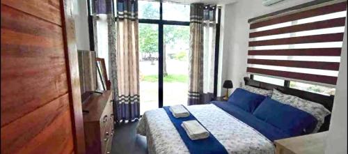 - une chambre avec un grand lit et des oreillers bleus dans l'établissement The Nova Scotia Resort Botolan, à Binuclutan
