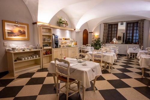 - un restaurant avec des tables et des chaises dans une salle dans l'établissement Cit'Hotel Sphinx - Hotel, à Montélimar