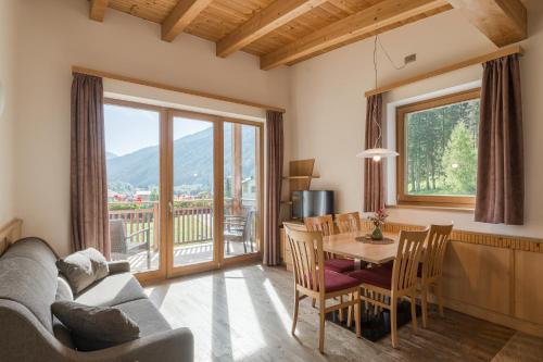a living room with a couch and a table and chairs at Residence Reisenschuh in Vipiteno