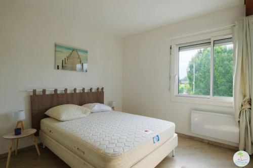 a bedroom with a bed and a window and a tub at Biscarrosse Bourg Appartement avec terrasse classé 1 étoile pour 4 personnes in Biscarrosse