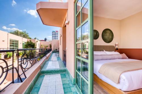 ein Hotelzimmer mit Bett und Balkon in der Unterkunft Casa Oliva in Mexiko-Stadt