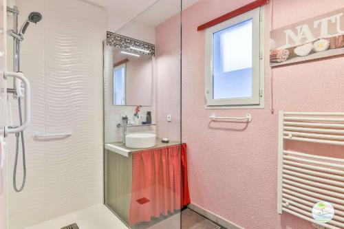 une salle de bain rose avec une douche et un lavabo dans l'établissement Parentis en Born Appartement avec balcon pour 4 personnes, à Parentis-en-Born