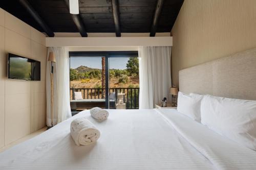 a bedroom with a large white bed with towels on it at Shanti Som in Monda