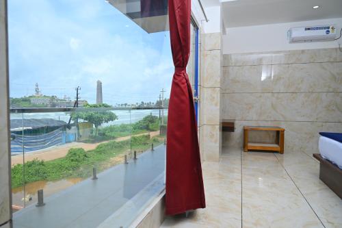a room with a large window with a view of the ocean at Blue Pearl Beach Guest House in Māvalli