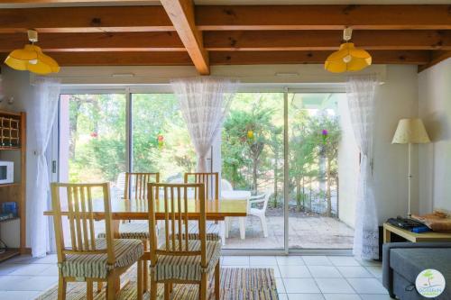 une salle à manger avec une table et des chaises et une fenêtre dans l'établissement Biscarrosse duplex 4 pers à 200 m du Lac de Navarrosse, à Biscarrosse
