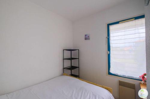 une petite chambre avec un lit et une fenêtre dans l'établissement Appartement avec Terrasse pour 2 ou 4 personnes classé 1 étoile, à Biscarrosse