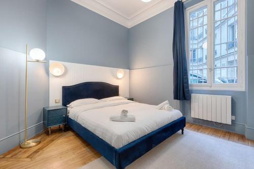 sypialnia z dużym łóżkiem i oknem w obiekcie MyKeypers Luxury Parisian Flat - Heart of Paris w Paryżu