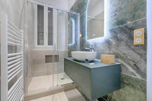W łazience znajduje się umywalka i przeszklony prysznic. w obiekcie MyKeypers Luxury Parisian Flat - Heart of Paris w Paryżu