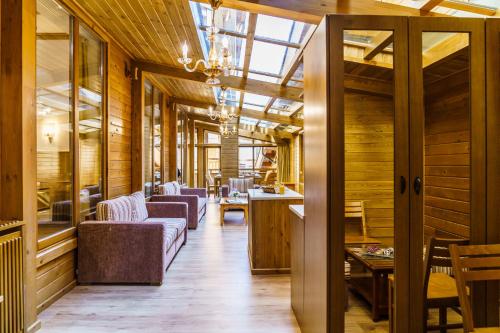 a room with wooden walls and wooden flooring with chairs and tables at Pirin Golf & Country Club Apartment Complex in Bansko