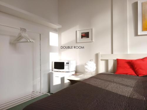 a bedroom with a bed with red pillows and a microwave at Loft 76 in Bremen