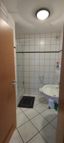 a bathroom with a tub and a toilet and a sink at FeWo Lindlar, Monteurwohnung in Lindlar