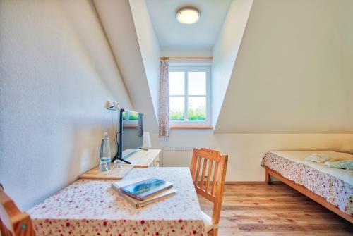 a bedroom with a table and a bed and a window at Penzion Pivnice - Jítravský Dvorec in Rynoltice