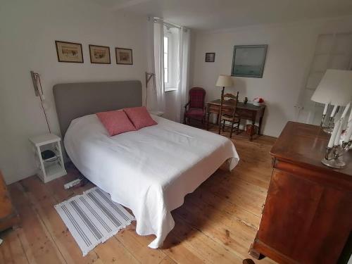 une chambre avec un lit blanc avec deux oreillers dessus dans l'établissement Saint-Jean de Luz,Maison de ville ancienne, face à la plage, à Sainte-Barbe