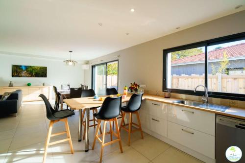 une cuisine avec une table et des chaises dans une cuisine dans l'établissement Biscarrosse Bourg Villa avec jardin classé 2 étoiles pour 6 personnes, à Biscarrosse