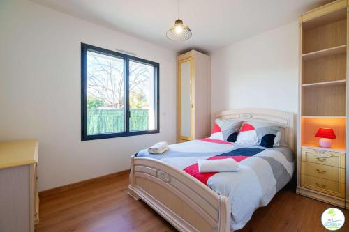 une chambre avec un grand lit et une fenêtre dans l'établissement Biscarrosse Bourg Villa avec jardin classé 2 étoiles pour 6 personnes, à Biscarrosse