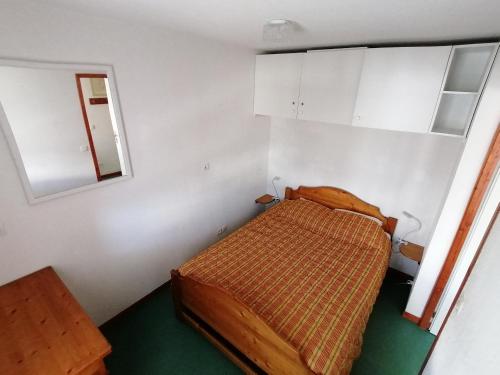 Dormitorio pequeño con cama y espejo en Appartement Saint-François-Longchamp, 2 pièces, 6 personnes - FR-1-635-109, en Saint-François-Longchamp
