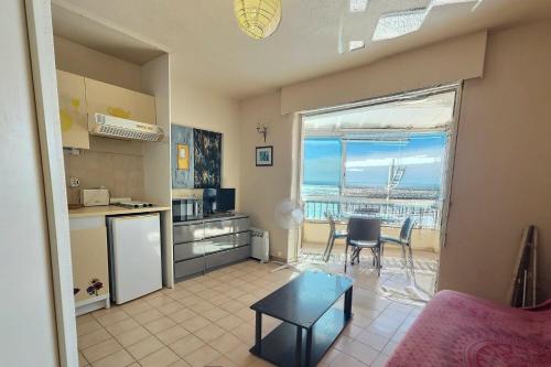 Il comprend un salon avec une cuisine, une table et une salle à manger. dans l'établissement Loq, à Valras-Plage