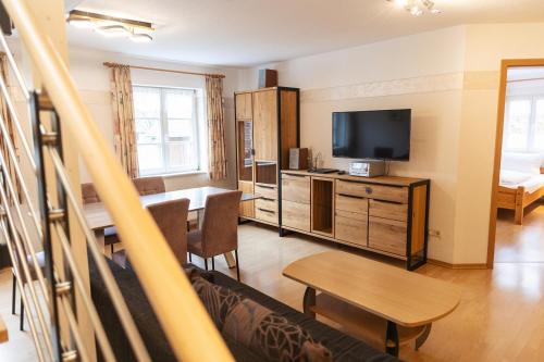 a living room with a dining table and a television at Gasthaus Kranz in Lausheim
