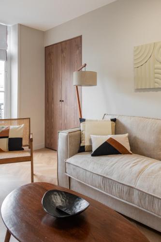 un salon avec un canapé et une table dans l'établissement The New Suites, Paris Centre, à Paris