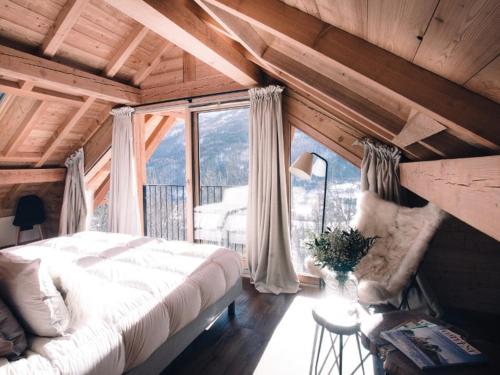 ein Schlafzimmer mit einem Bett und einem großen Fenster in der Unterkunft Chalet Luxueux 10 Pers. à Serre Chevalier - Terrasse, Local à Ski, Navette Gratuite - FR-1-762-18 in La Salle Les Alpes