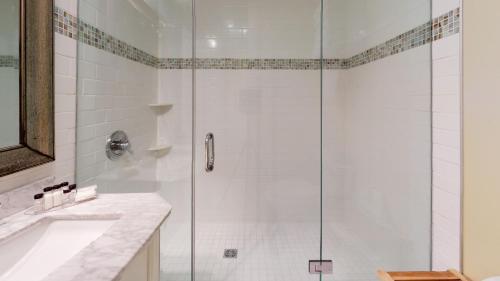 a shower with a glass door in a bathroom at Breezeway Boutique Hotel in Westerly