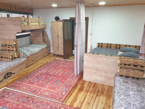 a room with two bunk beds and a rug at Uludağ ve Bursa manzaralı Lüks Dağ Evi in Yıldırım