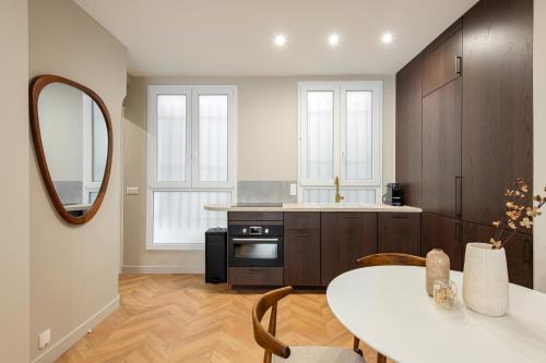 - une cuisine avec une table et un miroir dans l'établissement The New Suites, Paris Centre, à Paris