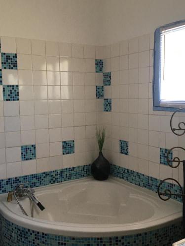 d'une baignoire avec un vase. dans l'établissement LE BONHEUR AVEC PISCINE ET JARDIN, à Cassis