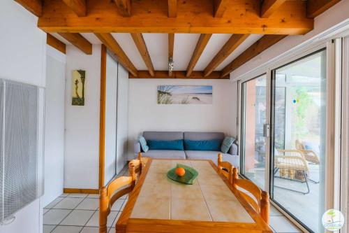 un salon avec une table et un canapé dans l'établissement Biscarrosse Lac Jolie maison avec jardin pour 4 personnes, à Biscarrosse