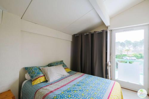 une chambre avec un lit et une fenêtre dans l'établissement Biscarrosse Lac Jolie maison avec jardin pour 4 personnes, à Biscarrosse
