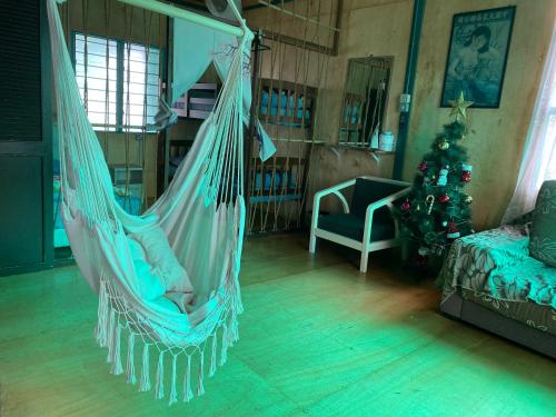 - un hamac dans un salon avec un arbre de Noël dans l'établissement New Famer Hut 1, à Brinchang