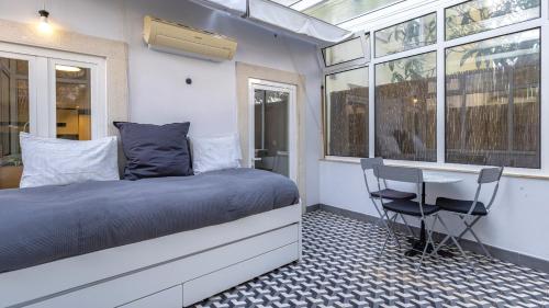 a bedroom with a bed and a table and chairs at Lisbon Fancy Duplex W/ Patio by LovelyStay in Lisbon