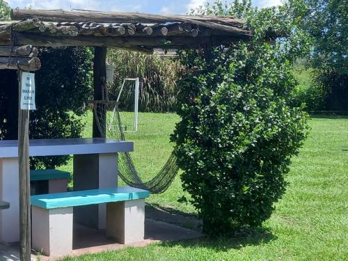a playground with a blue bench and a bush at Cabañas Villa del Sol in Salta