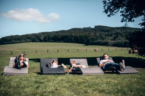 a group of people laying in chairs in the grass at Penzion Pivnice - Jítravský Dvorec in Rynoltice