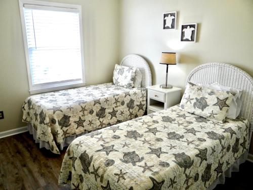 a bedroom with two beds and a window at Beachfront Bliss-Admirals Quarters II Oceanfront in Myrtle Beach