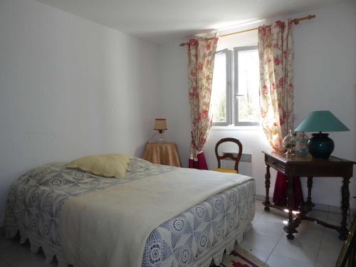 Schlafzimmer mit einem Bett, einem Tisch und einem Fenster in der Unterkunft Sanguinet Jolie maison mitoyenne pour 6 pers in Sanguinet