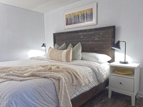 a bedroom with a large bed with a wooden headboard at Modern Town at Wintergreen 2min walk to Village Sauna in Blue Mountains