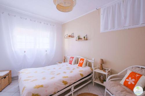 a bedroom with a bed and a chair and a window at Sanguinet Charmante maison avec jardin pour 6 personnes in Sanguinet