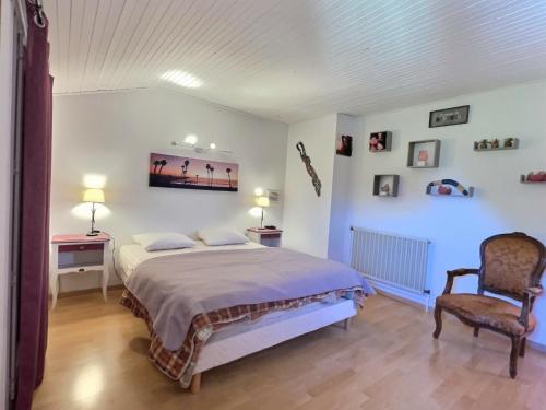 um quarto com uma cama e uma cadeira em Villa avec piscine à 10 min des plages. em Vendres