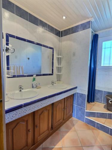 une salle de bain avec un lavabo et un grand miroir dans l'établissement Lest, à Vendres