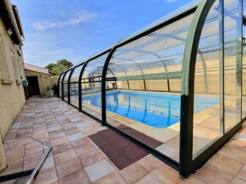 a swimming pool inside a building with glass walls at Lest in Vendres