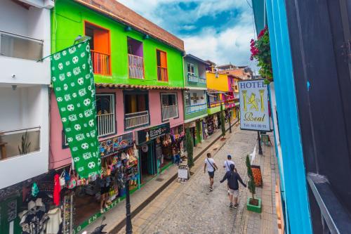 a group of people walking down a street with buildings at Hotel Real Guatapé in Guatapé