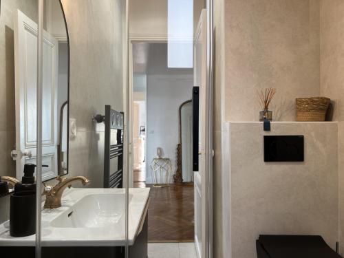uma casa de banho com um lavatório e um espelho em Luxueux appartement climatisé 3 chambres avec parking carré d'or em Nice