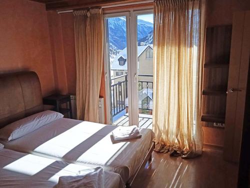 a bedroom with a bed and a large window at Apartamentos Candanchu 3000 in Candanchú
